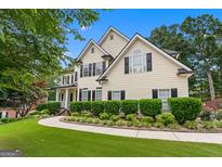 Two-story home with black shutters, manicured lawn and lovely, lush landscaping at 5833 Wembley Dr, Douglasville, GA 30135