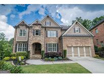 Stunning two-story home with stone and brick facade, manicured lawn, and a two-car garage at 6248 Sunshine Cove Ln, Buford, GA 30518
