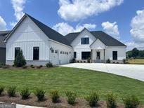 Beautiful new construction home with a black roof, white siding, well-manicured lawn, and a three-car garage at 319 Ruffian Cir # 71, Peachtree City, GA 30269