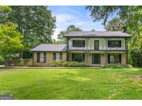 Charming two-story home featuring black accents, a brick facade, and a well-manicured lawn at 955 Landmark Dr, Sandy Springs, GA 30342