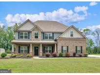 Inviting two-story brick home boasting a covered porch and well-manicured landscaping at 149 Elkins Blvd, Locust Grove, GA 30248