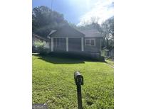 Charming single-story home featuring a cozy screened-in front porch and lush, green lawn at 297 Nw Anderson Ave, Atlanta, GA 30314