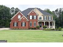 Beautiful two-story brick home with a well-manicured lawn and mature landscaping at 99 Oakwind Pt, Acworth, GA 30101