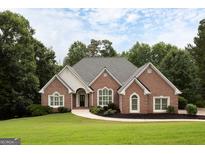 Charming brick home with manicured lawn, arched windows, and a classic, inviting entrance at 450 Riverwalk, Mcdonough, GA 30252