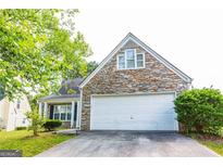 Charming home featuring a stone facade and a two-car garage, creating inviting curb appeal at 2545 Lake Royale Dr, Riverdale, GA 30296