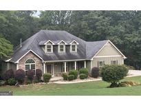 Charming one-story home with stone accents, a covered porch, and a beautifully landscaped front yard at 500 Barrington Farms Pkwy, Sharpsburg, GA 30277