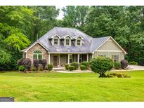 Charming home with a stone facade, inviting curb appeal, and lush green landscaping at 500 Barrington Farms Pkwy, Sharpsburg, GA 30277
