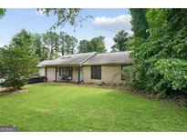 Charming single-story home with a well-manicured lawn and mature trees providing shade at 962 Brighton Dr, Lawrenceville, GA 30043