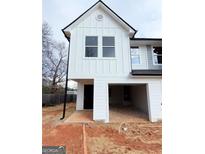 New construction features white siding, black trim, an open garage and covered entrance at 11594 E Lovejoy Rd # 1, Hampton, GA 30228