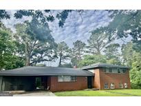 Charming single-Gathering home featuring classic brick and a welcoming carport at 1829 Joy Lake Rd, Morrow, GA 30260