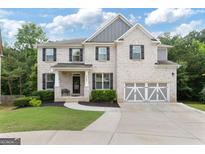 Charming two-story brick home featuring a well-manicured lawn, a two-car garage, and black shutters at 2307 Loughridge Dr, Buford, GA 30519