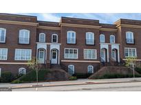 Brick townhomes feature black iron detailing, symmetrical windows, and raised entrances, adding to the curb appeal at 5139 Peachtree Road, Chamblee, GA 30341