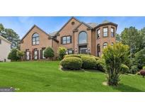 Attractive brick home with manicured lawn and mature landscaping at 3835 Hickory Branch Trl, Suwanee, GA 30024