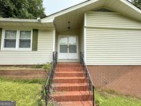Inviting front entrance with brick steps and white doors to a cozy home at 4540 Lindsey Dr, Powder Springs, GA 30127