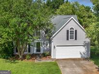 Charming two-story home with well-maintained lawn, mature trees and inviting front entrance at 404 Northwind Pl, Stockbridge, GA 30281