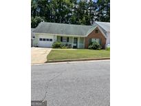 Charming single-story home featuring a well-maintained lawn and attached garage at 207 Oak N Cir, Stockbridge, GA 30281