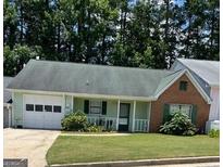 Charming one-story home featuring a well-maintained lawn, attached garage, and inviting front porch at 207 Oak N Cir, Stockbridge, GA 30281