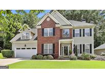 Charming two-story home featuring a brick facade, black shutters, well-manicured lawn, and an attached two-car garage at 139 Ardenlee Dr, Peachtree City, GA 30269