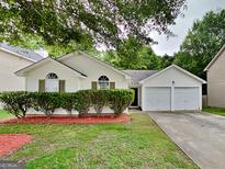 Charming single-Gathering home features a two-car garage and a well-manicured front yard at 6630 Pole Creek Dr, Lithonia, GA 30058