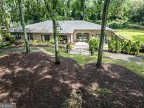 Charming brick home featuring manicured landscaping and a welcoming entrance, nestled amongst mature trees at 4187 Cherry Laurel Se Dr, Covington, GA 30014