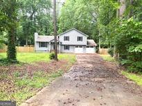 Traditional style home featuring a two-car garage and a spacious front yard at 7813 Sugarland Dr, Jonesboro, GA 30236