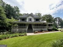 Charming two-story home with a large wraparound porch and well-manicured lawn at 3970 Governors Cir, Loganville, GA 30052