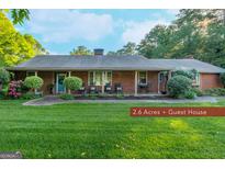 Charming single-story brick home with lush landscaping, and welcoming front porch at 8815 Campbellton St, Douglasville, GA 30134