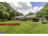 Stunning brick home on a sprawling lawn with mature trees and a detached guest house provides the ultimate in Southern living at 8815 Campbellton St, Douglasville, GA 30134