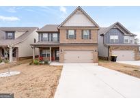 Charming two-story home with brick and siding, two-car garage, and well-maintained lawn at 2277 Church St, Hampton, GA 30228