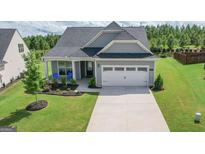 Charming single-Gathering home features a two-car garage, well-manicured lawn and inviting front porch at 104 Conway St, Peachtree City, GA 30269