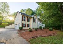 Charming two-story home with wood siding, a well-manicured lawn, and lush landscaping at 1858 Mcconnell Rd, Grayson, GA 30017