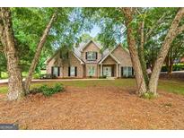 Charming brick home featuring a well-manicured front lawn and mature trees at 595 Mcgarity Dr, Mcdonough, GA 30252
