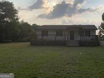 Inviting single-story home with a spacious front deck and a well-maintained lawn at 276 Oakland Rd, Mcdonough, GA 30253