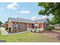 Charming red brick home with a cozy front patio and well-manicured lawn at 119 Holiday Road, Unit 301 Rd # 301, Buford, GA 30518