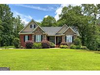 Charming single-story home featuring a stone and brick facade and a lush green lawn at 172 Sam Solomon Rd, Locust Grove, GA 30248