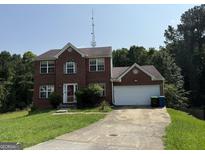 Charming two-story brick home with attached garage and a well-maintained front yard, perfect for Gathering living at 2355 Burdett Ridge Dr, South Fulton, GA 30349
