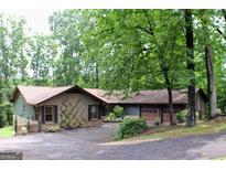 Charming brick home featuring a two-car garage and lush landscaping, creating an inviting curb appeal at 1310 Larkview Sw Dr, Lilburn, GA 30047
