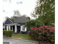 Charming blue house with a welcoming porch and beautiful rose bushes at 1012 Institute Nw St, Conyers, GA 30012
