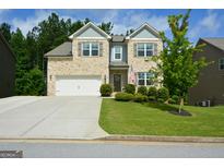 Beautiful two-story home with a well-manicured lawn and a two-car garage in a suburban neighborhood at 302 Aspen Valley Ln, Dallas, GA 30157