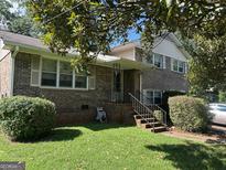 Traditional two-story brick home with a covered front porch, landscaped yard, and a charming curb appeal at 90 Cabriolet Trail, Mcdonough, GA 30253