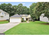 Charming single-story home with a well-manicured lawn and attached two-car garage at 1335 Vine Cir, Mcdonough, GA 30253