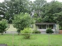 Cozy single-story home with a covered porch and partially-wooded front yard at 4 Skyland W Dr, Locust Grove, GA 30248