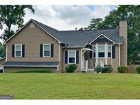Charming single-Gathering home with a well-maintained front yard, inviting curb appeal, and bay window at 565 Scarborough Rd, Ellenwood, GA 30294