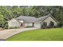 Charming home with a well-manicured lawn and a bright red front door surrounded by lush trees at 118 Whitfield Run, Peachtree City, GA 30269