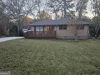 Charming brick home featuring a spacious front yard and wooden deck, perfect for outdoor enjoyment at 655 Shellnut Dr, Forest Park, GA 30297