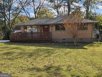 Charming brick home featuring a well-maintained lawn and a cozy front porch with wood railings at 655 Shellnut Dr, Forest Park, GA 30297