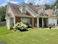 Charming home featuring beautiful landscaping, a brick accent wall, and a well-manicured lawn at 221 Turtle Cv, Carrollton, GA 30116