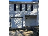 Charming townhome featuring a single-car garage and a welcoming front entrance at 2511 Pine Tree Trail, Atlanta, GA 30349