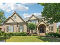 Charming two-story brick home with a manicured lawn and a grand, arched entryway, offering curb appeal at 2452 Stone Manor Ne Dr, Buford, GA 30519