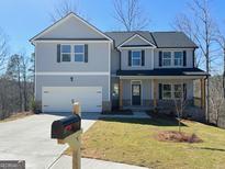 Charming two-story home featuring a manicured lawn, attached garage, and classic architectural details at 5342 Legacy Trl # 30, Douglasville, GA 30135